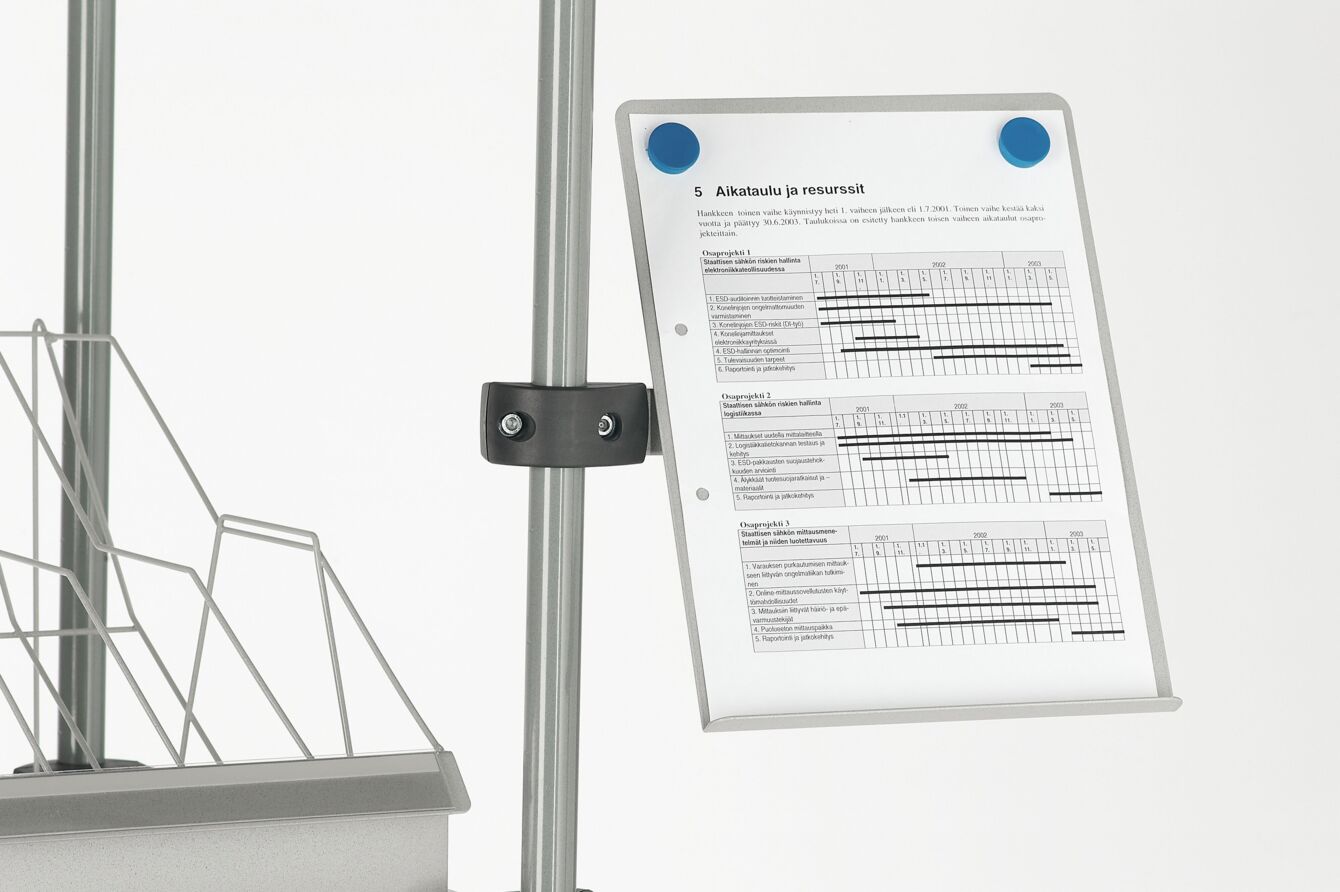 The image displays a sheet of paper with tables, attached to a stand. Next to the sheet is a wire-like holder. The colors are simple and the structure is functional.