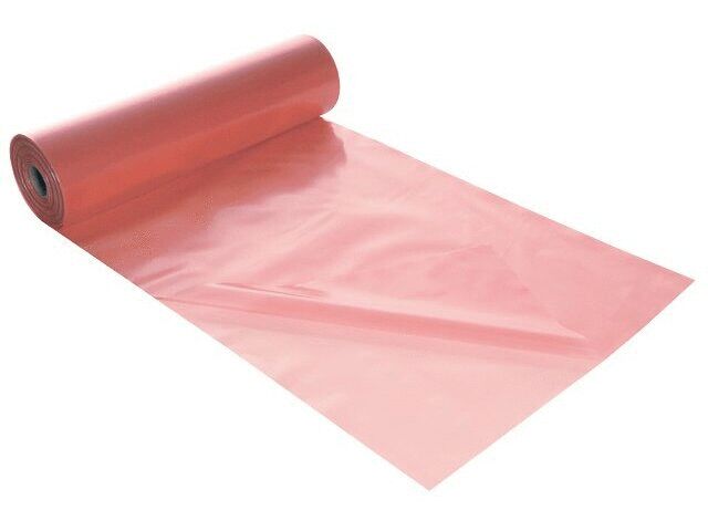 The image shows a roll of pink, shiny plastic material. Part of the material lies flat on a surface, while the rest is rolled up.