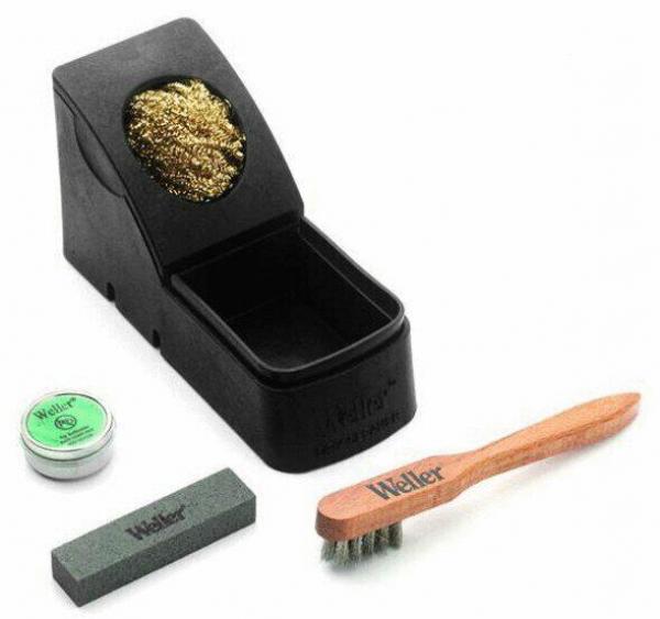 The picture shows a cleaning kit: a black box with golden contents, a green tube, a gray sponge, and a wooden brush with metal bristles. All parts are arranged on a white background.