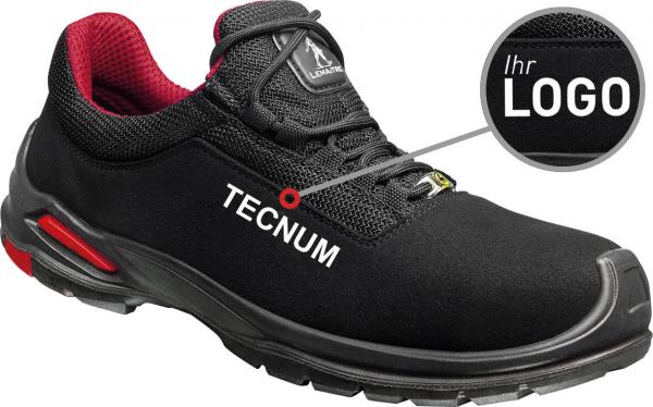 The image shows a black sports shoe with red accents. It has a simple shape and the word "TECNUM" in white lettering on the side. A note indicates where the logo can be placed.