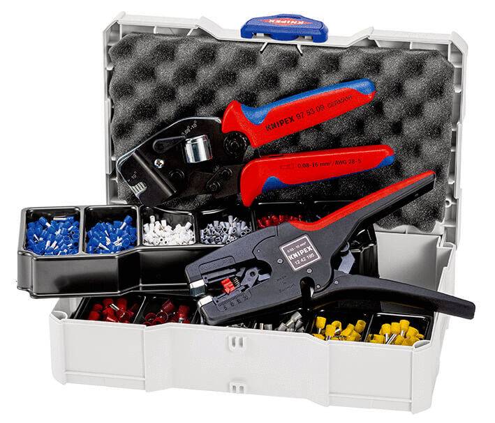 The image shows an open toolbox with various tools. Inside are pliers with red-blue handles and several compartments with colored wire terminals in red, blue, and white.