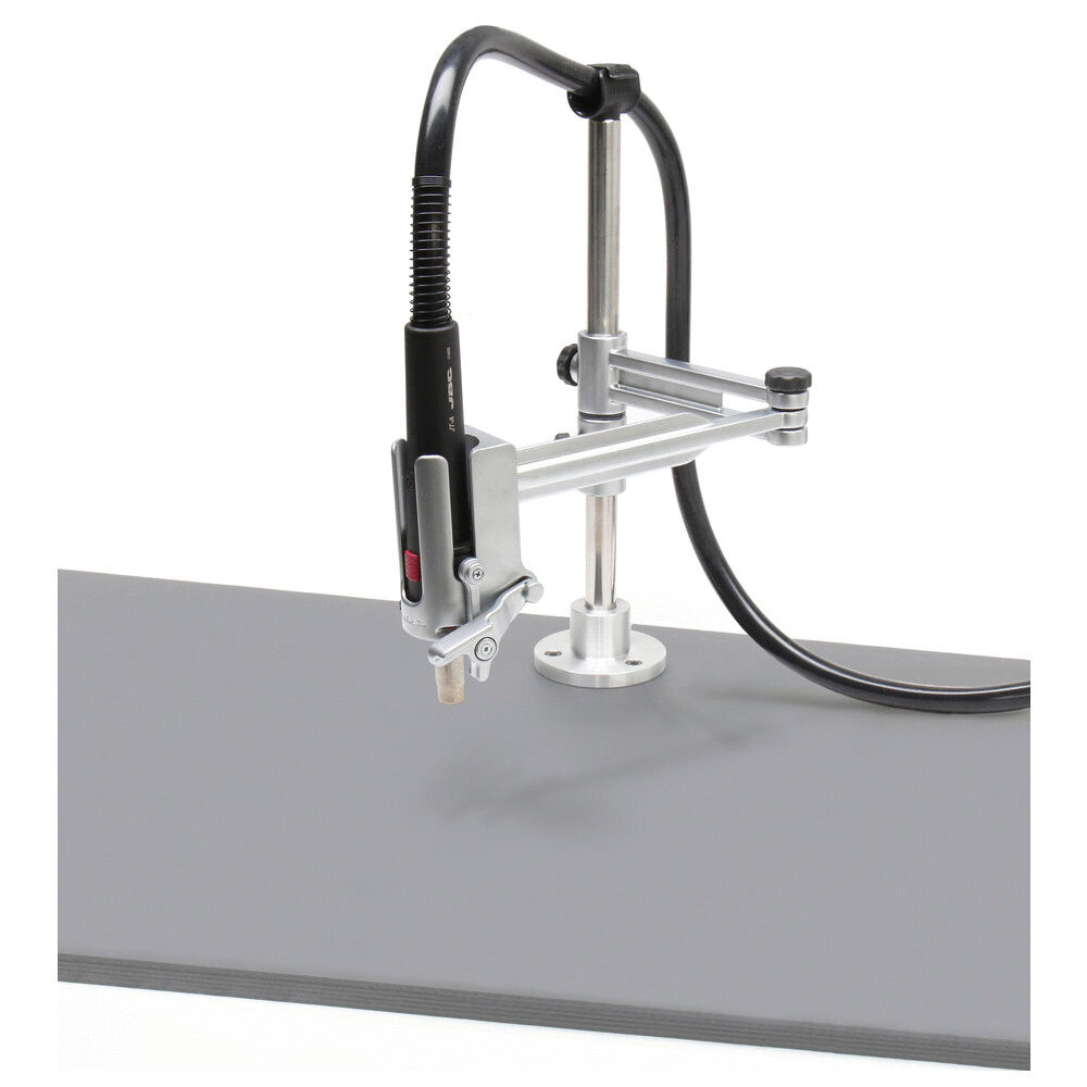 The image shows an assembly fixture with a welding device attached to a metal arm. The arm is mounted on a sturdy base, and a flexible cable connects the parts.