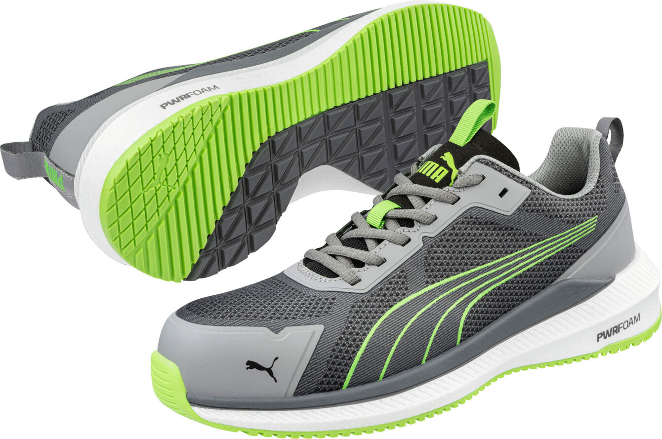 The image shows a pair of gray athletic shoes with green accents. They have a padded sole and a modern design, ideal for active use. The laces are in the center.