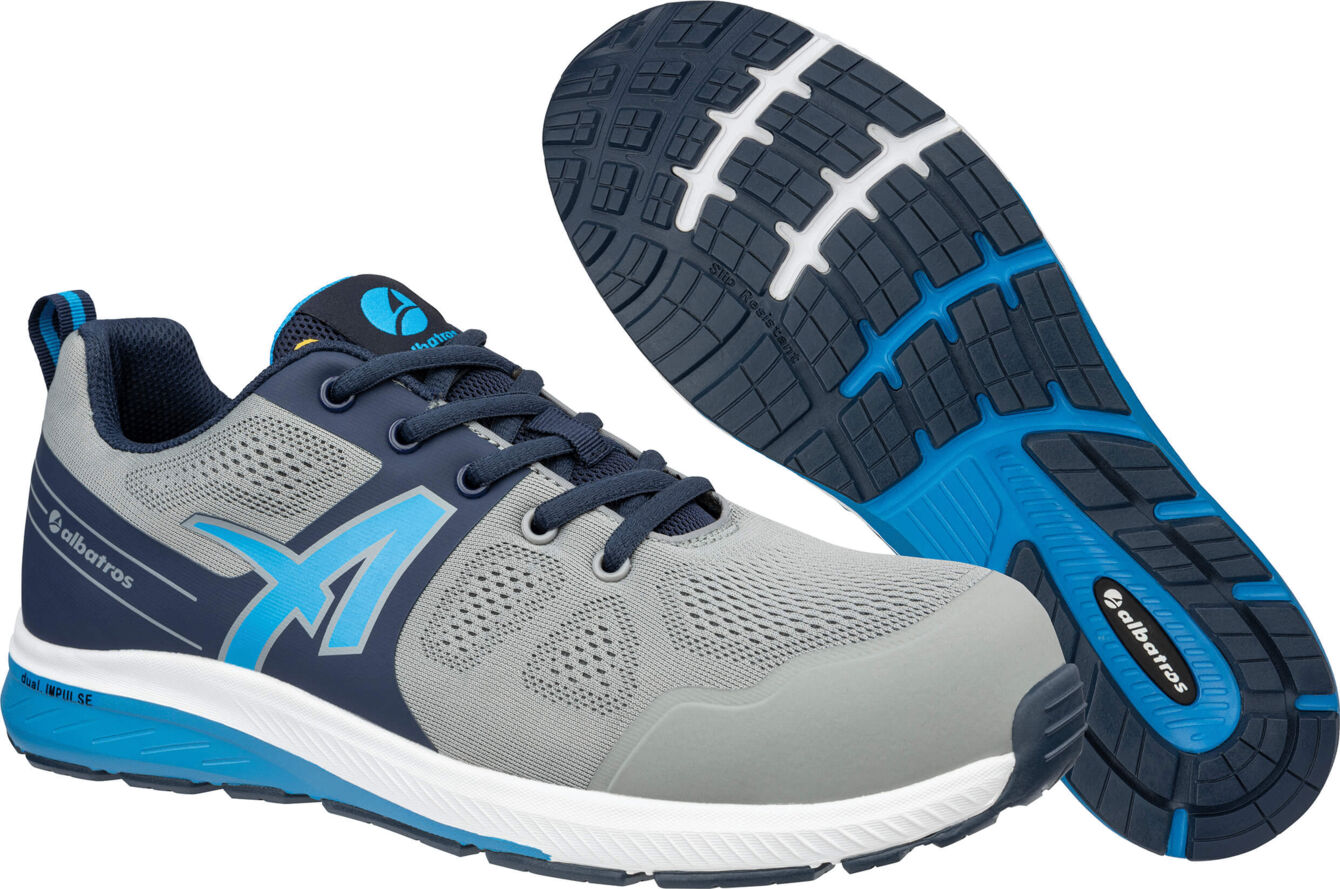 The image shows a sports shoe in gray and blue. The shoe features a breathable upper and a textured sole with a wavy pattern. The laces are black.