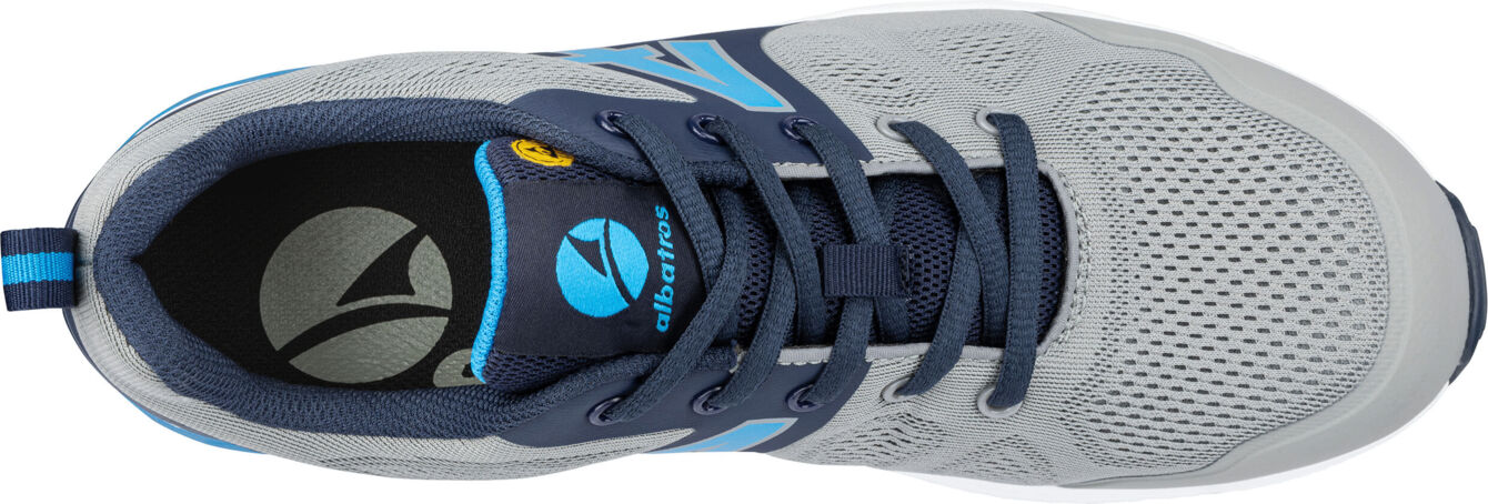 The shoe is made of gray mesh material with blue accents. It features a round toe area, a padded tongue, and laces that run down the center. The sole is lightweight and flexible.