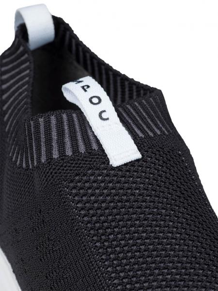 The image shows a black shoe in close-up style. It features a knit-like surface with an elastic collar and a white pull tab at the back.