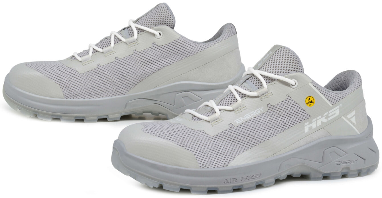 The image shows a pair of gray athletic shoes with a breathable mesh upper and a sturdy, rubberized sole. They have white laces and a modern, sporty shape.