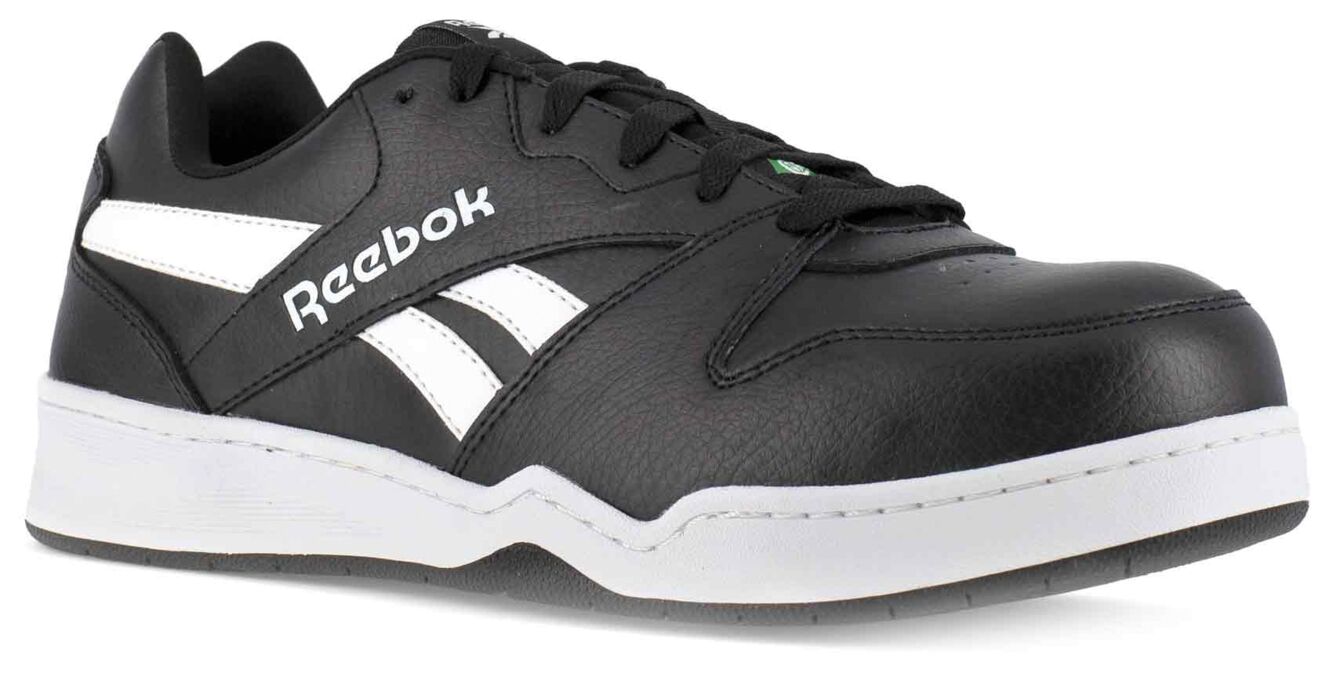 Das Bild zeigt einen schwarzen Reebok-Sportschuh aus Leder. Er hat weiße Details und eine flache, griffige Sohle. Die Schnürsenkel sind schwarz und das Design ist sportlich und modern.