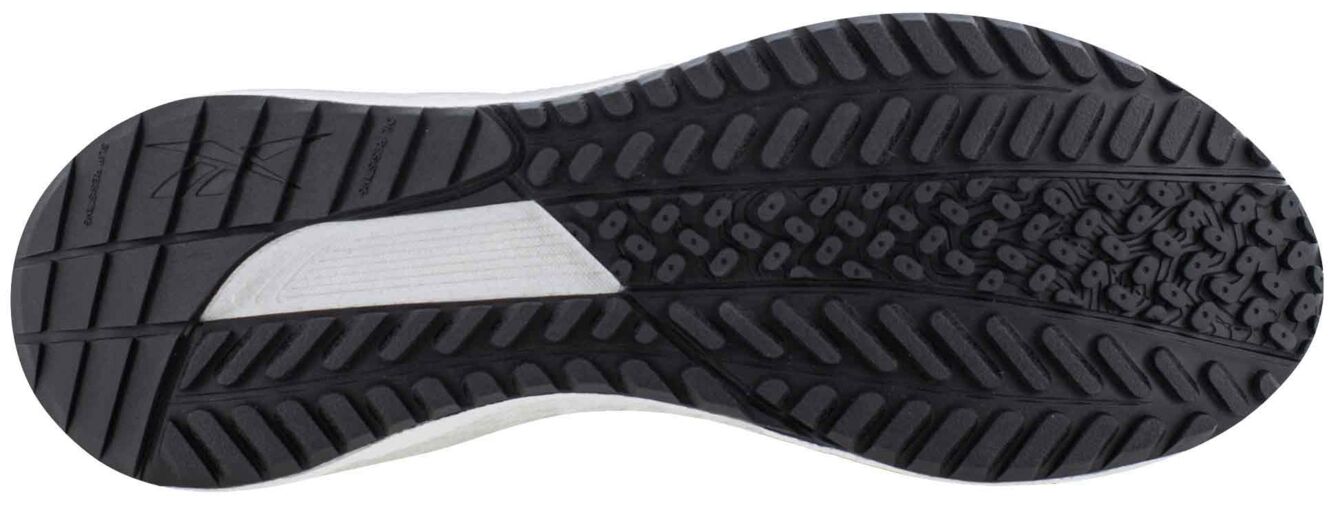 The image displays the underside of a sports shoe. The sole features a textured pattern with various grooves and studs in black and white. It is slightly curved.