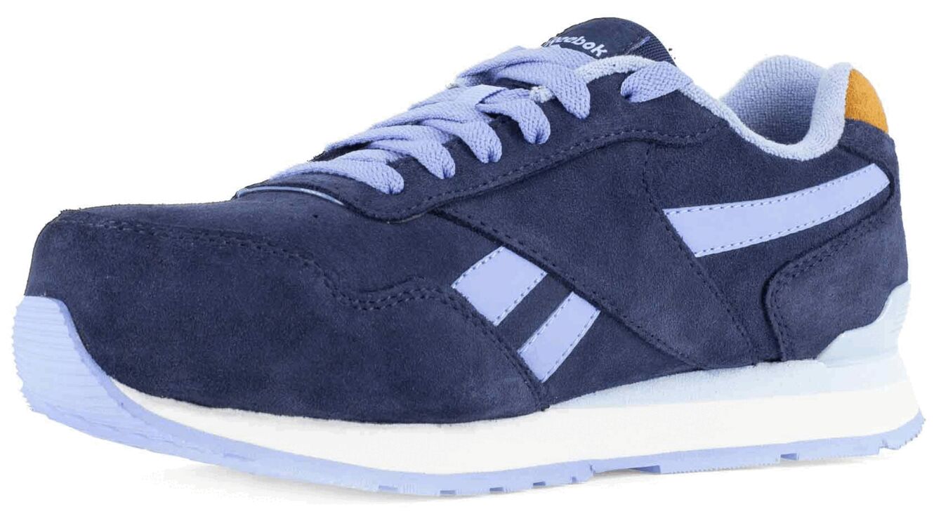 The image shows a blue suede sneaker. It features light blue accents, white laces, and a white sole. The design is sporty and timeless.