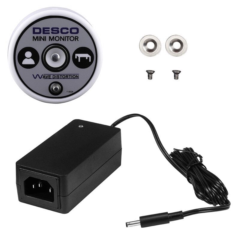 The image shows a small, round device labeled "DESCO MINI MONITOR". Next to it is a black power supply with a long cable and connector plug. Two screws are also depicted.