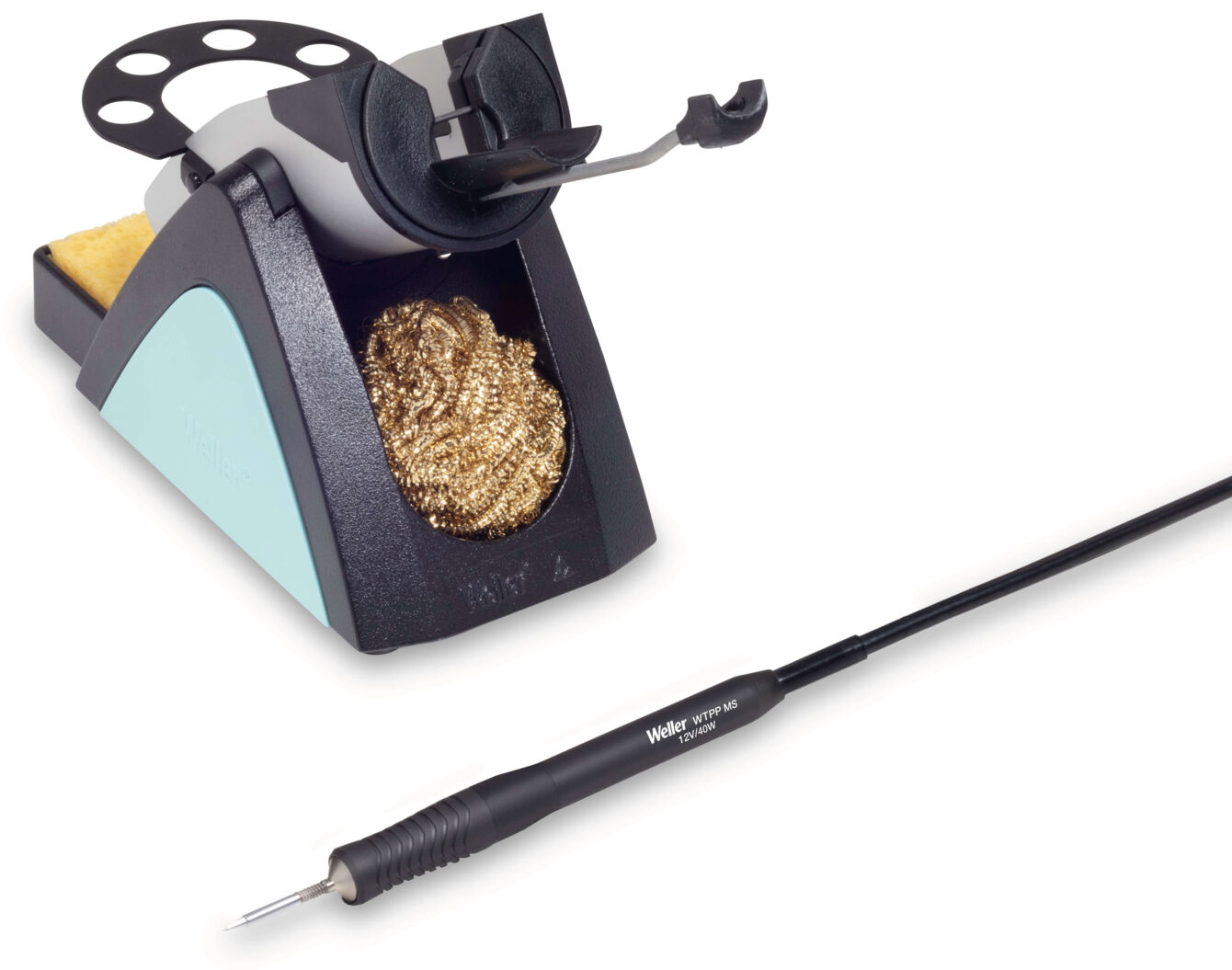 The image shows a soldering iron with a stand. The stand has a round holder and is black with a blue element. Next to it is a soldering tip cleaner with a wire ball.