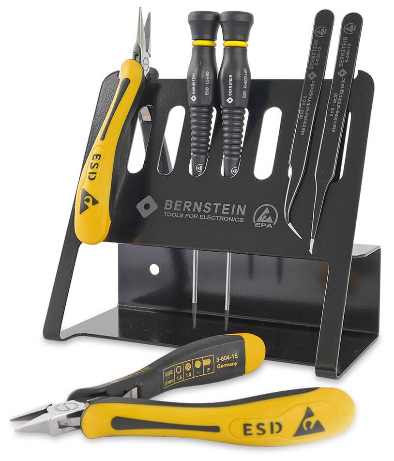 In the picture, various power tools are arranged on a black stand. These include a pair of pliers and several screwdrivers with yellow handles and ESD marking.